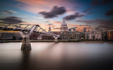 Cityscape view of St Paul's Cathedral and Millennium Bridge at sunset over the River Thames