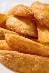 Close-up view of golden and crispy potato wedges seasoned with spices.