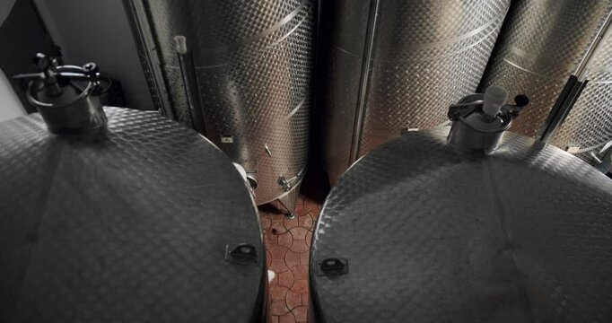 Controls the quality of production equipment in wine factory. Winemaker looking equipment for distillation and fermentation at wine factory.