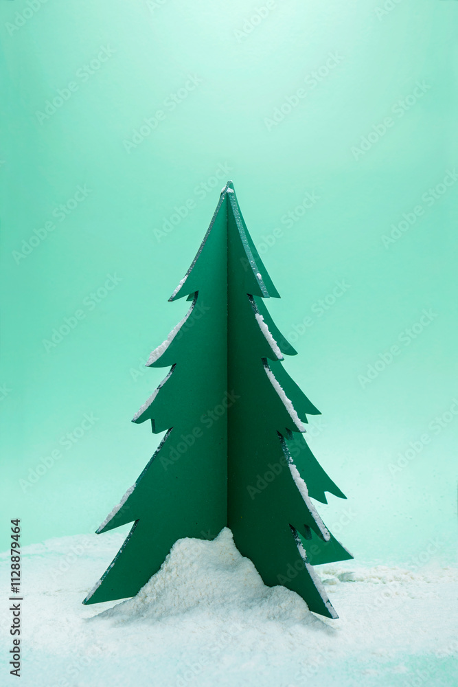 Poster closeup view of a christmas tree miniature with snow on a colored background