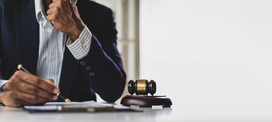 Lawyer reading legal documents and preparing to sign a contract. Lawyer is carefully reviewing...