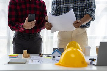 Architect colleague in the office is talking with a contractor and discussing the correct planning...
