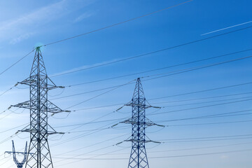 High-voltage wires and poles are covered with frost on a frosty winter day.