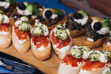 Catering table, beautifully decorated banquet with variety different food snacks appetizers on christmas corporate birthday party event or wedding celebration, canape, salad, delicatessen setting