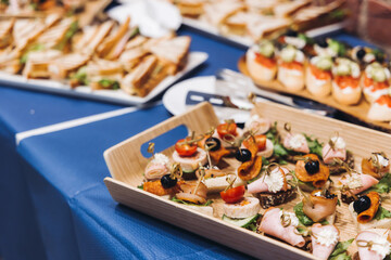 Catering table, beautifully decorated banquet with variety different food snacks appetizers on christmas corporate birthday party event or wedding celebration, canape, salad, delicatessen setting