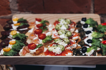 Catering table, beautifully decorated banquet with variety different food snacks appetizers on christmas corporate birthday party event or wedding celebration, canape, salad, delicatessen setting