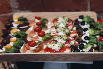 Catering table, beautifully decorated banquet with variety different food snacks appetizers on christmas corporate birthday party event or wedding celebration, canape, salad, delicatessen setting