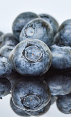 Makrofotografie von frischen Blaubeeren, die ihre lebendigen Farben und die feinen Details der Hautstruktur zeigen. Die natürliche Schönheit der Beeren wird in der Nahaufnahme besonders betont