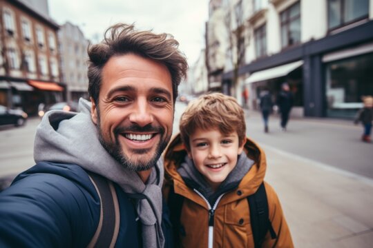 Close up of a father and his son taking selfie while in city