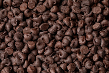 Dark brown chocolate chips close up full frame as background