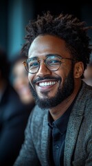 Smiling businessman in a meeting wearing glasses and a grey blazer