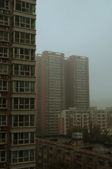 Obraz premium foggy outlook of apartment buildings scenery, foggy urban landscape in autumm