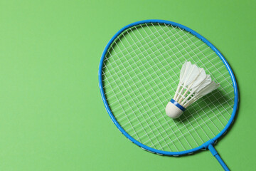 Badminton racket and white badminton shuttlecock on color background 