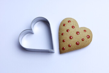 Gingerbread heart and cookie cutter on white background. Valentine's day concept.