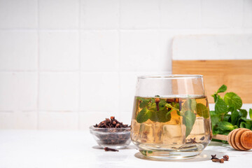 Clove mint julep summer infused drink, clove water or tea.  Ayurvedic, antiseptic, anti-inflammatory and antioxidant drink, brewed dry clove remedy in glass