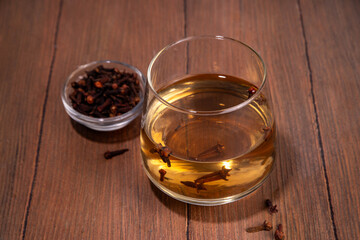 Clove Water or Tea, organic infused drink. Ayurvedic, antiseptic, anti-inflammatory and antioxidant drink, brewed dry clove remedy in glass
