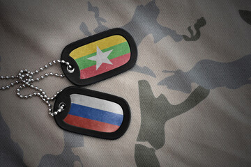 vintage army blank, dog tag with flag of myanmar and russia on the khaki texture background....
