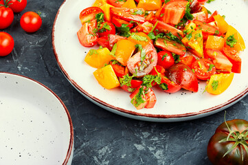 Fresh salad preparation with tomatoes and greens.