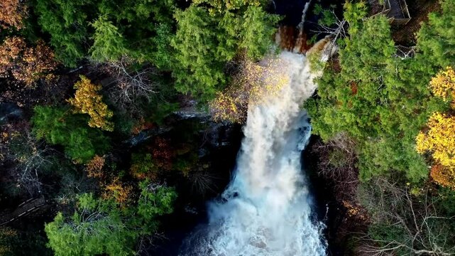 Aerial footage of Bushkill Falls in Lehman Township, Pennsylvania, capturing the stunning waterfalls amidst the Pocono Mountains, surrounded by lush greenery and rugged terrain breathtaking nature