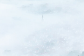 Kirchturm in Bissingen an der Teck ragt aus dem Nebel heraus. 