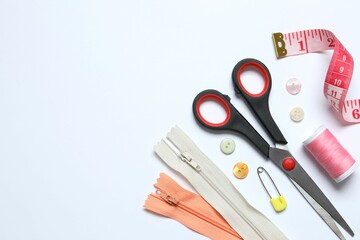 Flat lay composition with different sewing supplies on white background