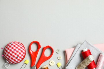 Flat lay composition with different sewing supplies on gray background