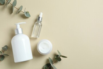 Natural cosmetic products with eucalyptus leaves on color background, top view