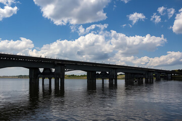 A bridge over a river. A bridge with clouds and a river in the sky. Blue bridge in the nature with blue sky. Blue sky and clouds over the lifestyle bridge in nature.