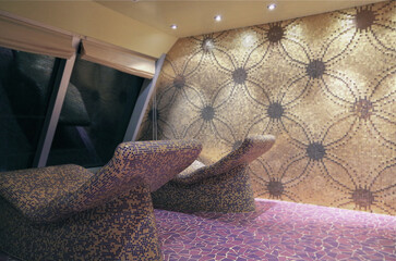 Thermal suite with heated loungers in mosaic tile design or relaxation chairs in spa or wellness...