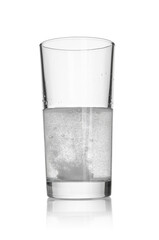 Tablet dissolving in a glass of water on white background