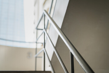 Fototapeta premium Building apartment stairway with handrail, using for emergency escape route. Building interior part photo, selective focus. 