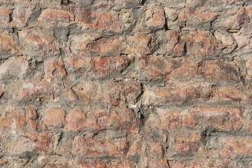 Damaged brick structure surface of the ancient city wall. Building part for texture, close-up.