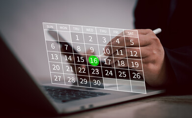 businessman marks date on transparent digital calendar displayed over a laptop screen, efficient...
