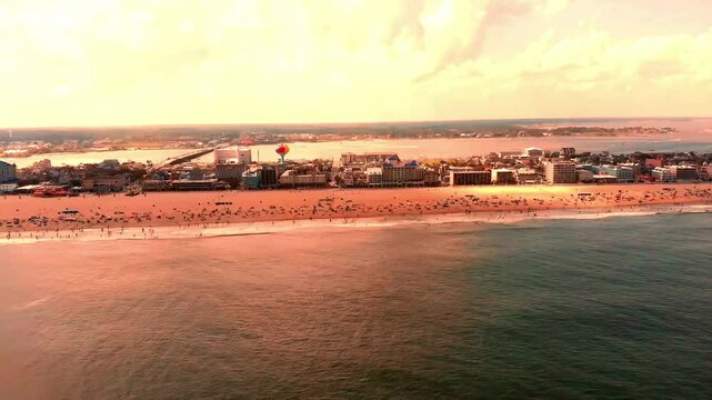 Aerial footage of Ocean City, USA, featuring the town's beach, sea, vibrant city streets, highways, buildings, and people enjoying the coastal lifestyle. Perfect for showcasing urban, tourism, and bea