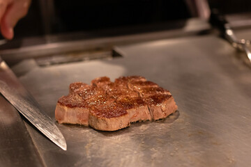 Chef cooking a delicious steak on the grill.