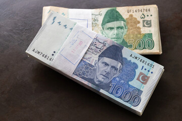 Pakistani currency note closely on wooden background.