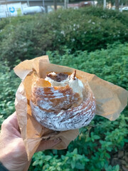 chocolate croissant bitten by a person showing the chocolate in the image, croissant held by a boy's hand