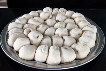 Freshly prepared dough balls on a kitchen surface.