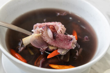 Squid ink soup with lemongrass and chili; traditional meals in the south of Thailand.