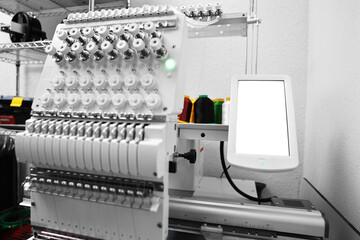 Modern embroidery machine with spools of thread indoors
