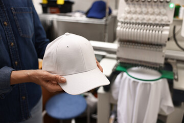 Woman with blank baseball cap for print indoors, closeup