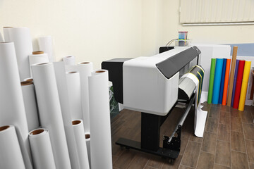 Wide-format printer and paper rolls indoors. Printing house
