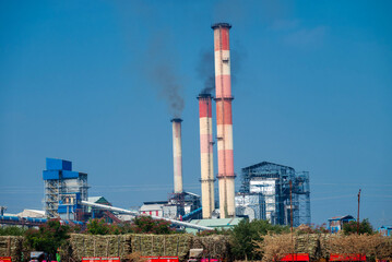Obraz premium sugar mill, sugar factory in India, A sugar cane mill is a factory that processes sugar cane to produce raw sugar or plantation white sugar. Increasing air pollution to factory smoke.