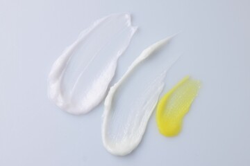 Samples of cosmetic products on white background, top view