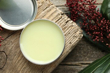 Natural solid perfume and skimmia plant on wooden table, flat lay