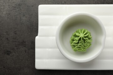 Hot wasabi paste on grey table, top view. Space for text