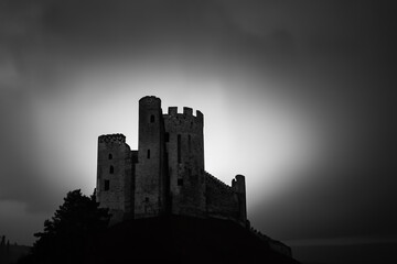 Obraz premium Black and white photo of castle. A castle lit up in the night darkness. A castle glares at night. A castle with a glare of light and lifestyle darkness at night.