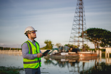 Engineer is inspecting the construction site and planning the construction of an office building for a factory.