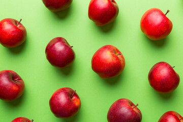 Many red apples on colored background, top view. Autumn pattern with fresh apple above view