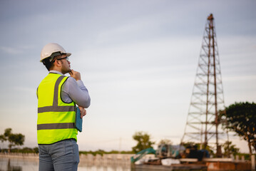 Engineer is inspecting the construction site and planning the construction of an office building for a factory.